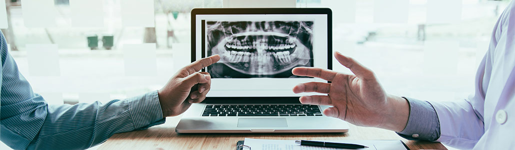 Zahnarzt zeigt mögliche Implantate am Röntgenbild